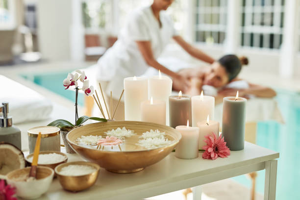Cropped shot of various pampering essentials in a spa with a woman getting a beauty treatment in the background